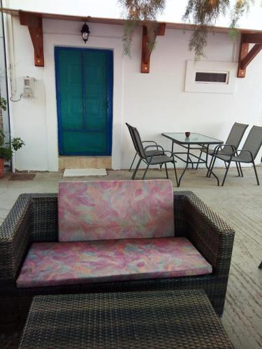 a couch sitting on a patio with chairs and a table at Beachfront Apartment Kato Zakros in Káto Zákros