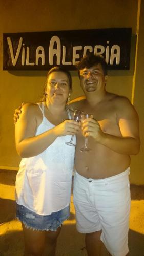 a man and a woman holding glasses of wine at Vila Alegria in Bombinhas