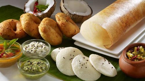 einen Tisch mit Brot und verschiedenen Arten von Speisen in der Unterkunft SGRT Residency in Vellore