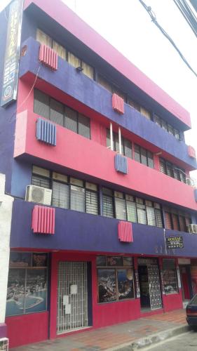 un edificio rojo y morado con ventanas en Hotel El Exito, en Santa Marta