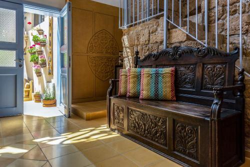 a wooden bench with pillows on it in a hallway at Arabesque Arts & Residency in ‘Akko