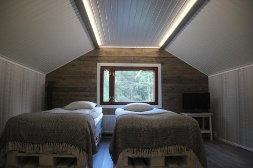 ロヴァニエミにあるBeautiful holiday home (studio) in Rovaniemiのベッド2台と窓が備わる屋根裏部屋です。