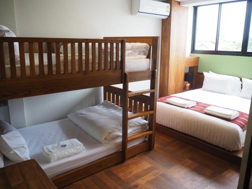 a bedroom with two bunk beds and a window at Boonnark Bed Night Bazaar no car parking in Chiang Mai