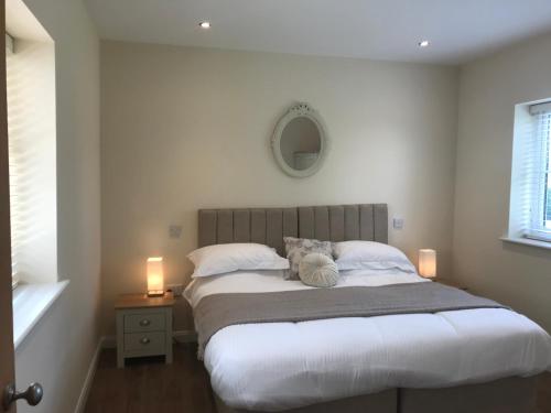 a bedroom with a bed with a teddy bear on it at Spring Hill Cottages in Towcester
