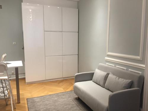 - un salon avec un canapé et un placard blanc dans l'établissement Residence sur Cour, à Paris
