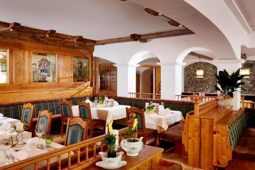 a restaurant with tables and chairs in a room at Romantikhotel Zell am See in Zell am See
