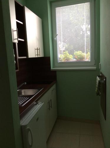 a small kitchen with a sink and a window at Ubytování Lábadi in Rohatec