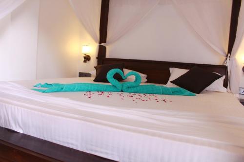 a bedroom with a bed with two swans made out of hearts at Turtle Reef Guest in Mirissa