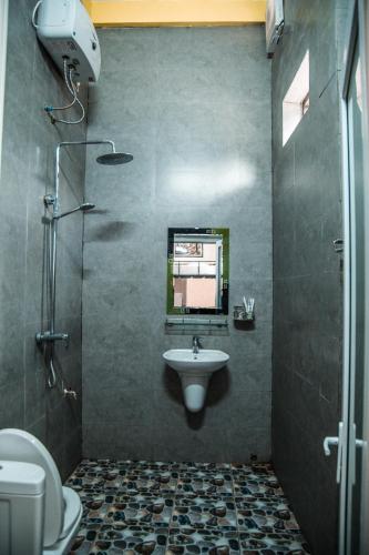 a bathroom with a sink and a toilet and a mirror at Phong Nha Village House in Phong Nha