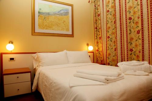 a bedroom with a white bed with towels on it at Aksai Residence in Aksay