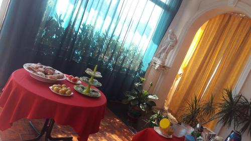a table with a red table cloth with food on it at Villa Midolo in Noto Marina