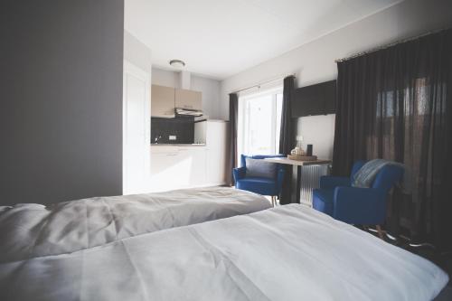 a bedroom with a bed and two blue chairs at Lodgepark Goitzsche GmbH in Große Mühle