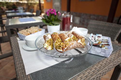 a table with a glass plate with pastries on it at B&B Villa Eleonora in Realmonte