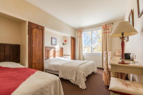 a bedroom with two beds and a window at Le Manoir de l'antiquité in Challans