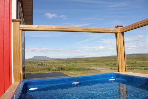 a hot tub with a view of the desert through a window at Blue View Cabin 1B With private hot tub in Reykholt