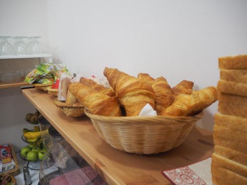 a basket of croissants on a table with bread at Hotel La Terraza in Miño