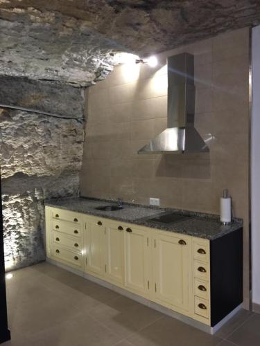 cocina con fregadero y fogones en Casa Cueva Un Rincón en la Roca, en Setenil