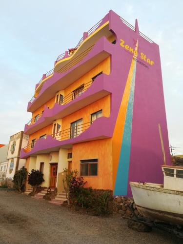 a building with a rainbow painted on it at Zena Star in Tarrafal