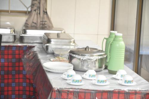 a kitchen counter with plates and a pot and dishes at Hotel Ideal in Dar es Salaam
