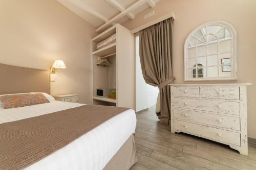a bedroom with a white bed and a dresser at Cas'E Charming House in Caserta