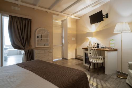 a bedroom with a bed and a desk and a table at Cas'E Charming House in Caserta