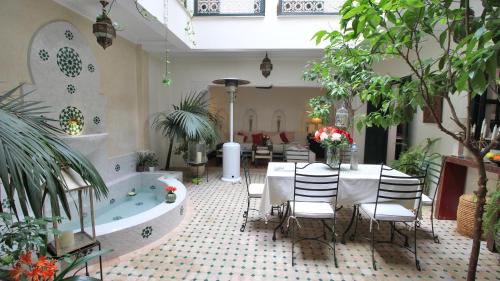 a room with a bath tub and a table and chairs at Riad Kasbah Baraka in Marrakesh