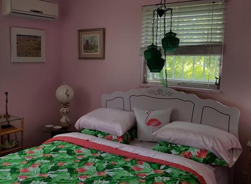 1 dormitorio con 1 cama con 2 almohadas y ventana en Bajamar Your Second Home Guest Property en Freeport