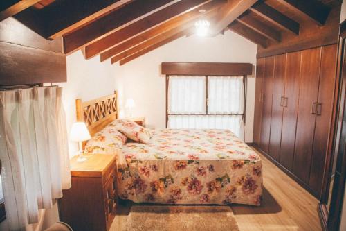 1 dormitorio con cama, mesa y ventana en La Casina, en Cangas de Onís