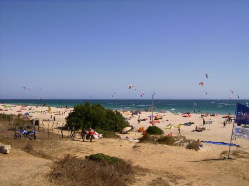 a group of people on a beach flying kites at Hotel Copacabana Tarifa Beach in Tarifa