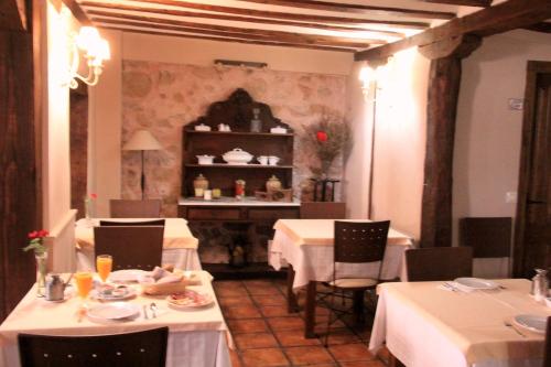 a restaurant with tables and chairs with white table cloth at La Casona de Lucía in Sigüenza