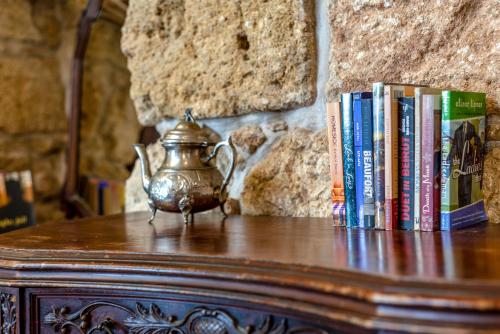 a table with books and a tea pot and books at Arabesque Arts & Residency in ‘Akko
