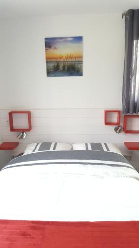 a bedroom with a bed with red accents and a painting at Appartement Alouette France in Pessac