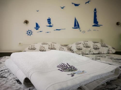a bed with a white blanket and blue signs on the wall at Apartments 4you in Vir