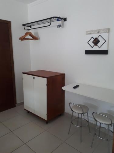 a desk and two chairs in a room at Pippo Suites Guarujá in Guarujá