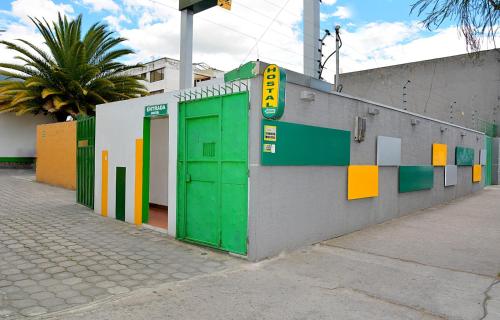 a building with green doors on the side of it at Hostal Terra 3 - BASE AÉREA in Quito