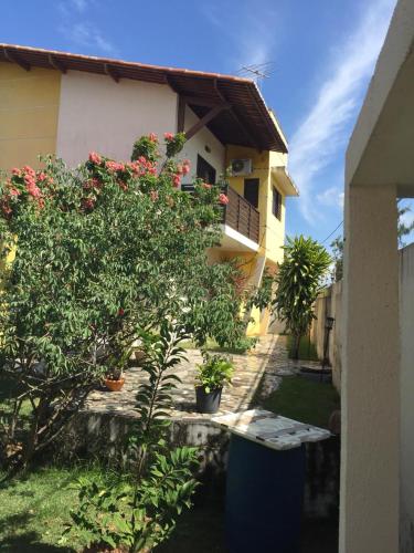 a house with a tree in front of it at Pousada Res. Belmont in Pirangi do Norte