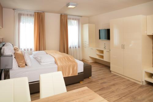 a hotel room with a bed and a tv at Főtér Rezidencia 2 in Győr