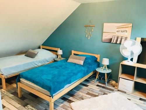 two beds in a room with blue walls at CosyStudio2 Site du Futuroscope in Jaunay-Marigny