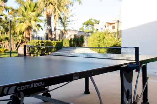 a ping pong table with a net on it at Villa mare Fontane Bianche in Fontane Bianche