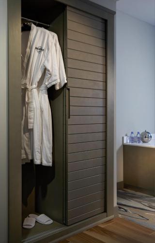 a wardrobe with white clothes and shoes in a room at Hard Rock Hotel Daytona Beach in Daytona Beach