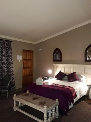 um quarto com uma cama grande e uma mesa em Charilo em Dullstroom