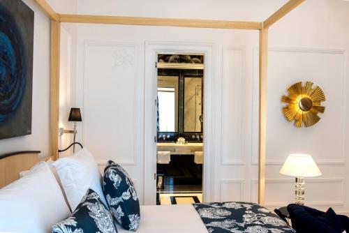 a bedroom with a bed and a mirror and a sink at Hotel Casa Palacio María Luisa in Jerez de la Frontera
