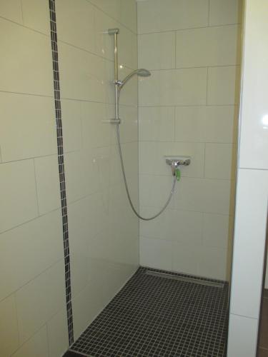 a shower with a hose in a bathroom at Ferienhaus Absmeier in Bad Griesbach