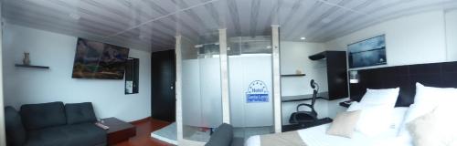 a bedroom with a bed and a chair in a room at SUITE SANTA LUCIA HOTEL BOUTIQUE in Sogamoso