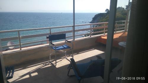 a balcony with a chair and a view of the ocean at Between the Airport and the Harbour in Mytilene