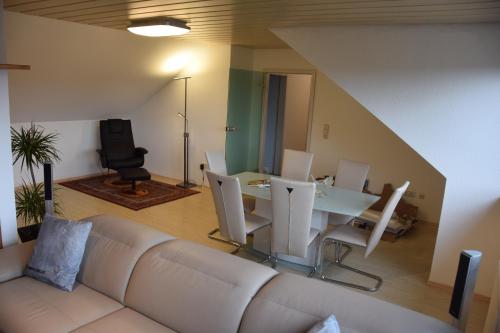 a living room with a white couch and a table at Lichtenau - Bertholdes Traum in Lichtenau
