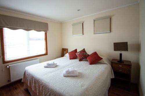 a bedroom with a bed with two towels on it at Departamentos Costanera in Punta Arenas