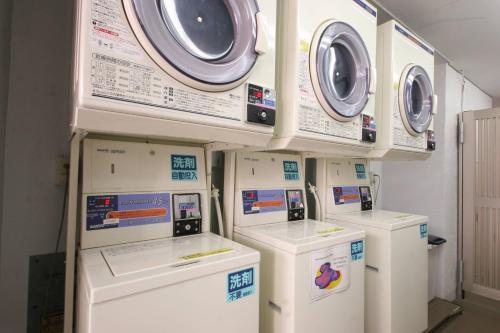 a bunch of washers and dryers in a room at Sakura Hotel Ikebukuro in Tokyo