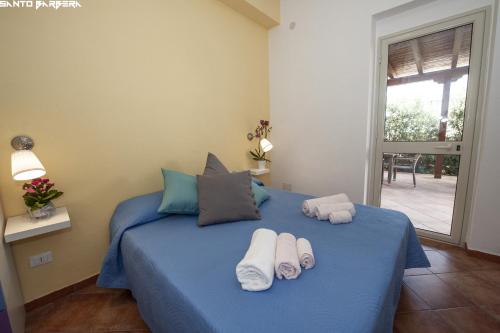 Un dormitorio con una cama azul con toallas. en B&B Villa Eleonora en Realmonte