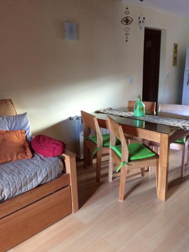 a room with a table and a bed and a table and chairs at 678 Mascardi Roca Malen in San Martín de los Andes